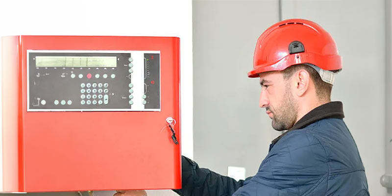 Electrician working on a fire alarm box